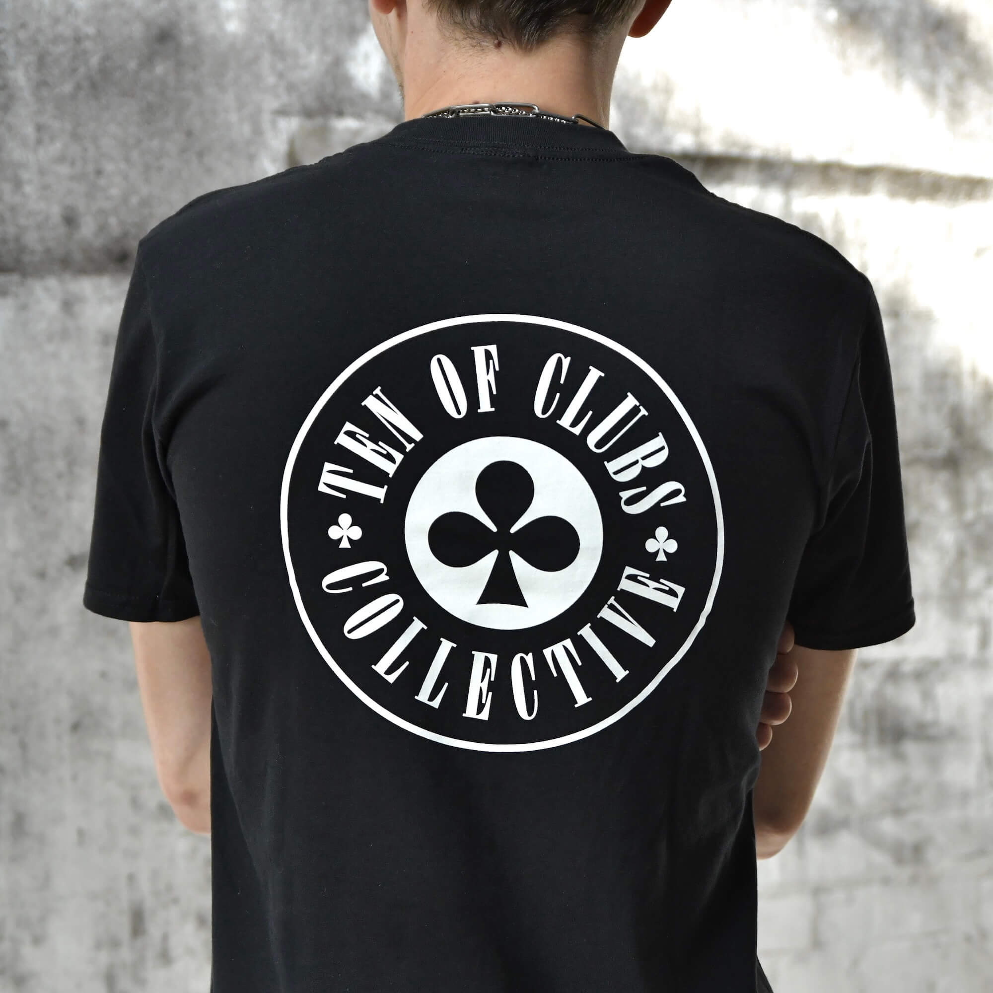 Model wearing Gunslinger Tee black graphic t-shirt with TEN OF CLUBS COLLECTIVE logo back print | alt streetwear by TEN OF CLUBS
