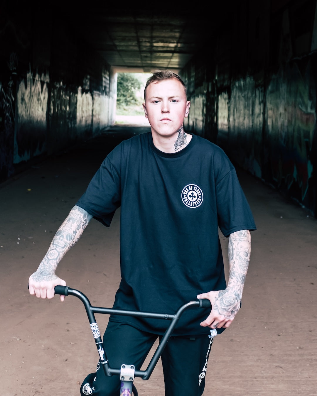 Man wearing TEN OF CLUBS Wave Tee on a BMX bike