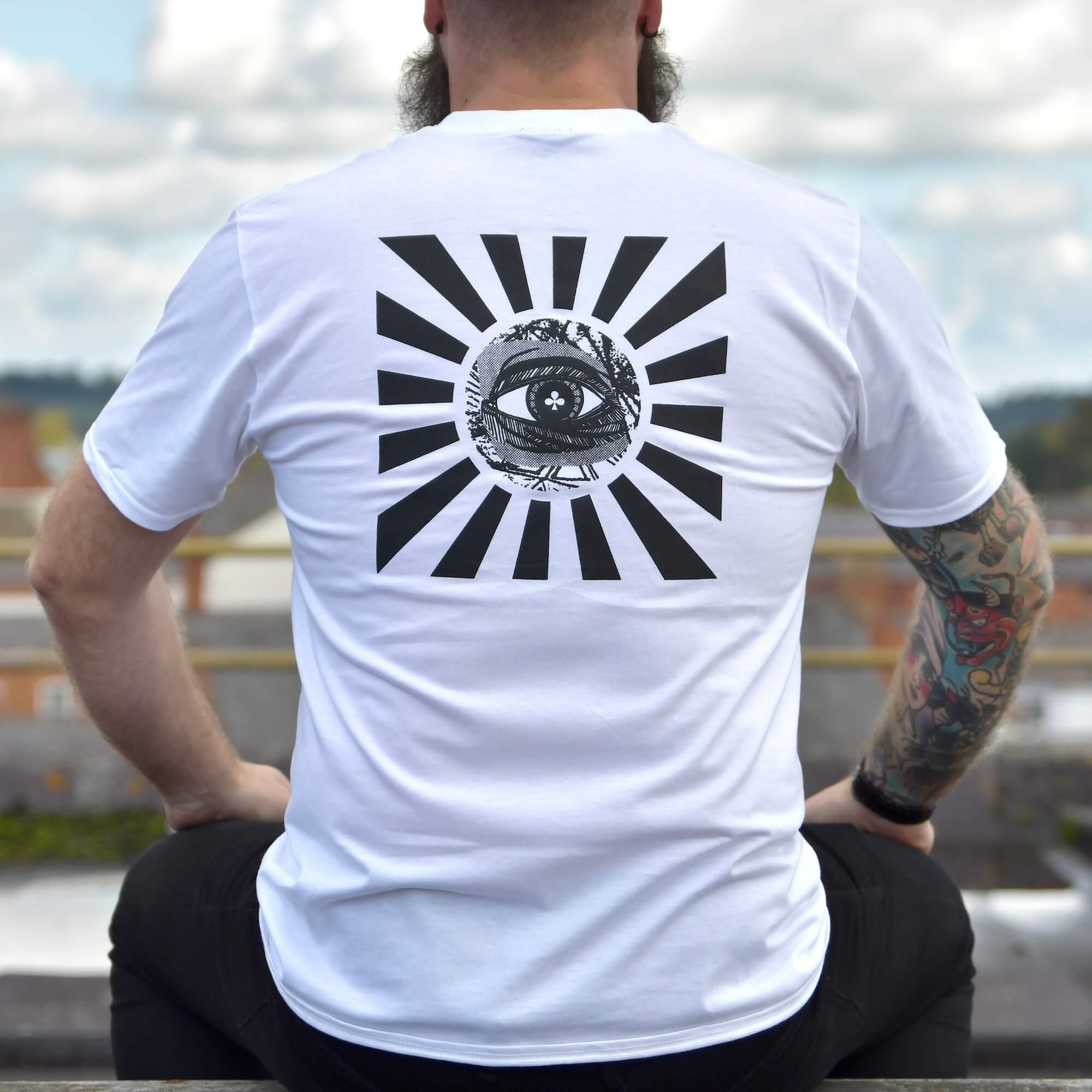 Model wearing Rise And Shine Tee white graphic t-shirt with Eye of Providence back print | alt streetwear by TEN OF CLUBS