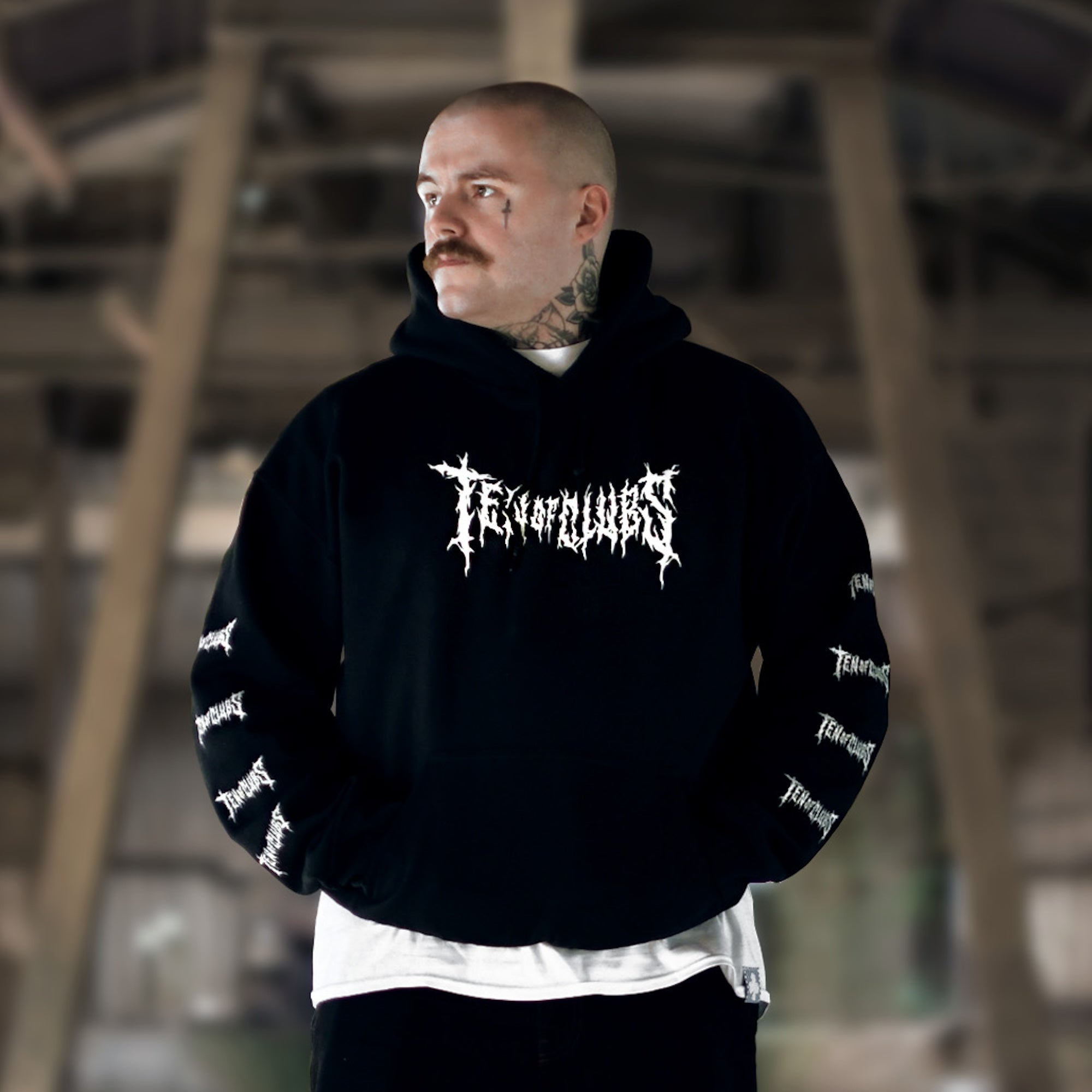 Tattooed man in black TEN OF CLUBS Spike Hoodie