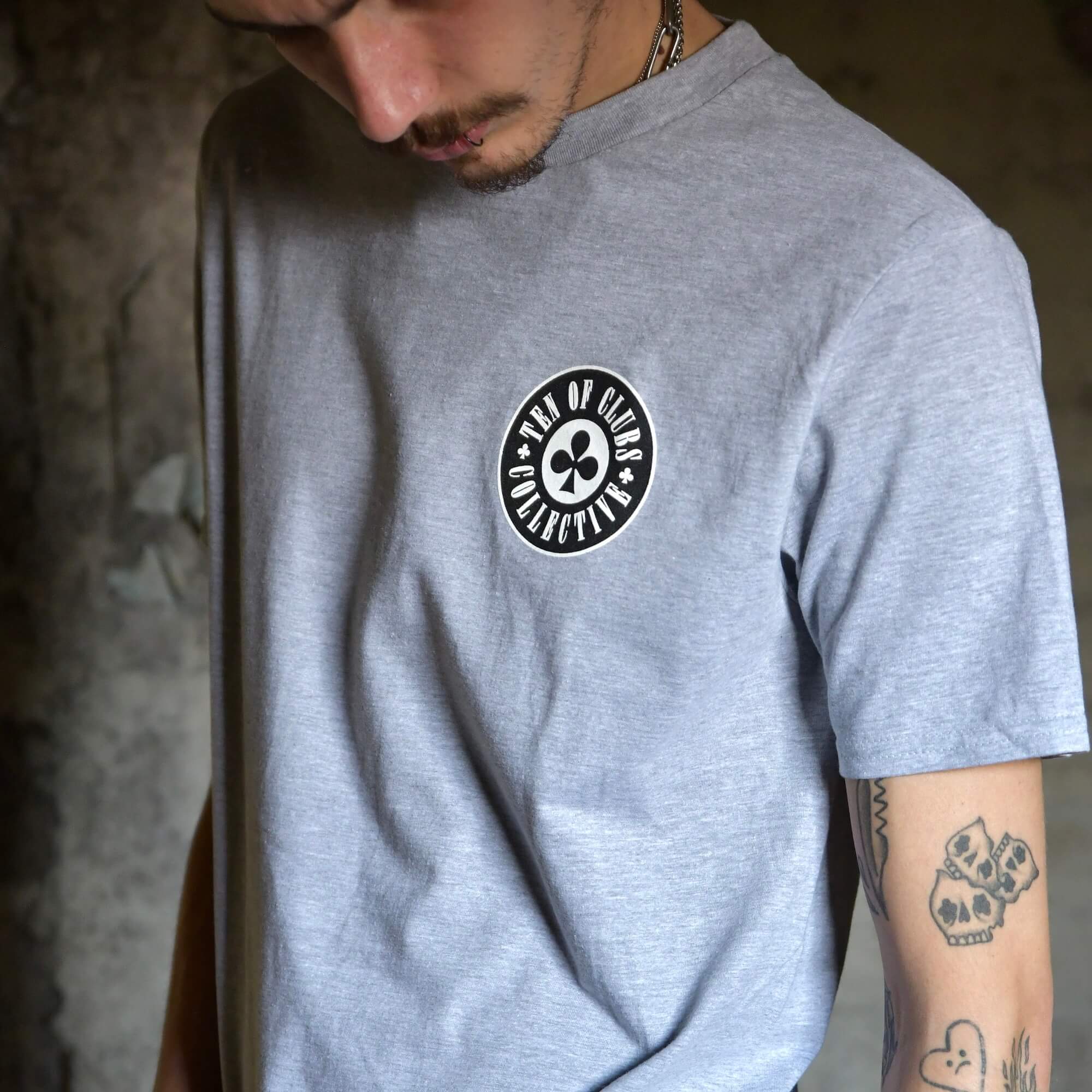 Model wearing Gunslinger Tee grey graphic t-shirt with TEN OF CLUBS COLLECTIVE logo chest print | alt streetwear by TEN OF CLUBS