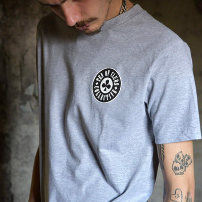 Model wearing Gunslinger Tee grey graphic t-shirt with TEN OF CLUBS COLLECTIVE logo chest print | alt streetwear by TEN OF CLUBS